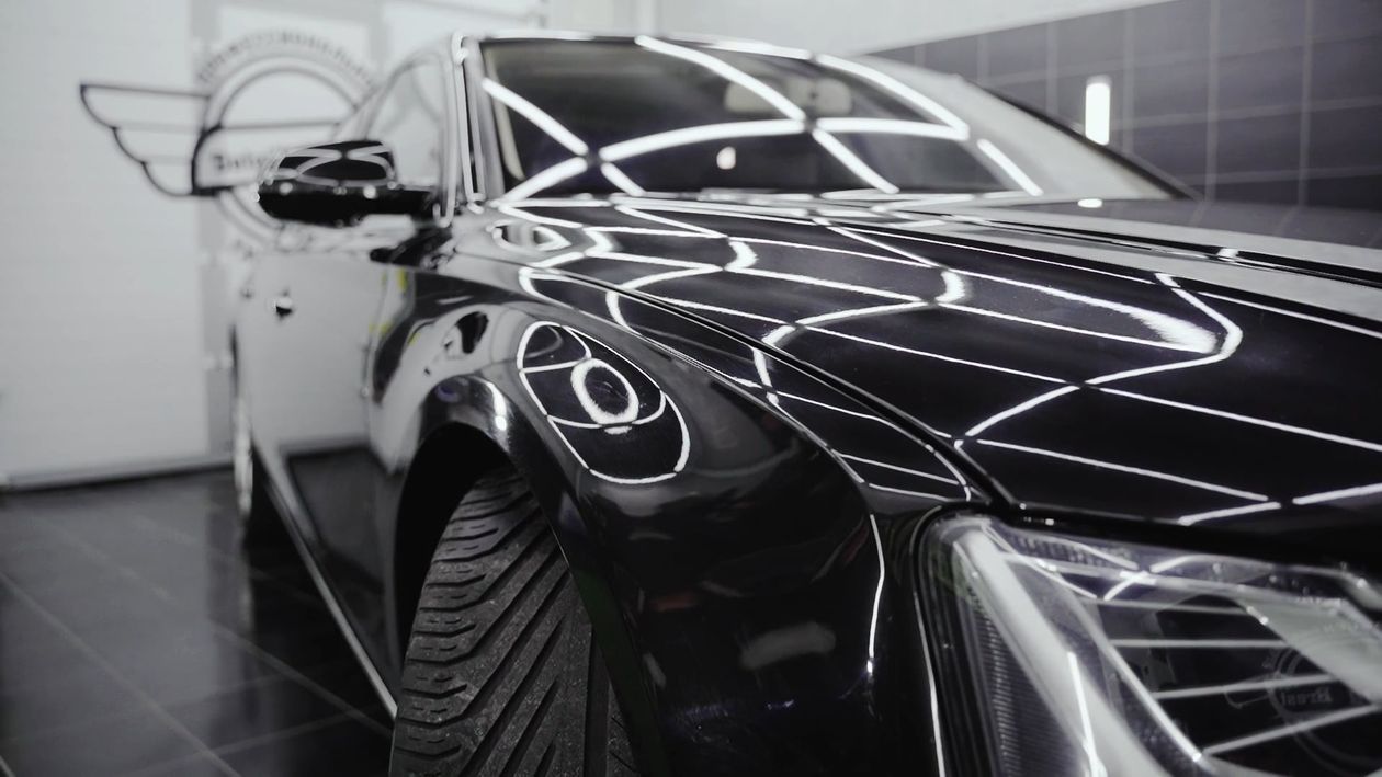 Reflections across polished black paint
